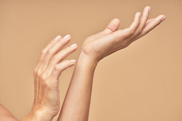 Spa treatment. Beautiful female hands isolated on beige background