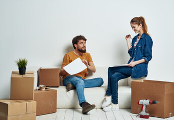 Cheerful young couple in an apartment boxes with things moving 