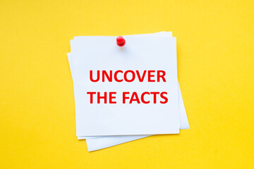 Word uncover the facts on white sticker with yellow background