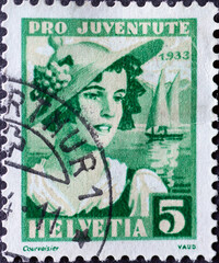 Switzerland - Circa 1933 : a postage stamp printed in the swiss showing the portrait of a woman from Vaud in historical costume and Geneva lake