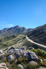 Mountain landscape with cars driving up a dusty pass