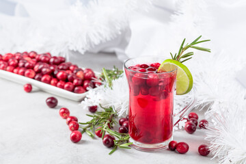 Christmas cranberry drink with berries, lime, and rosemary.