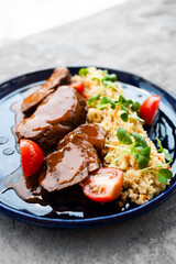 beef cheeks with couscous stew on a blue platter
