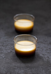 Flan pudding cream caramel in a glass Cup on a dark  gray background
