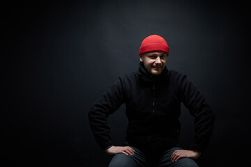 Portrait of a person in red hat, black background