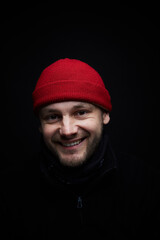 Portrait of a person in red hat, black background