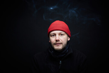 Portrait of a person in red hat, black background