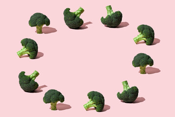 Green Broccoli head lay down on pink background
