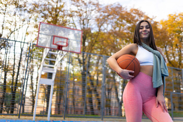 Athletic girl with a ball on basketball court