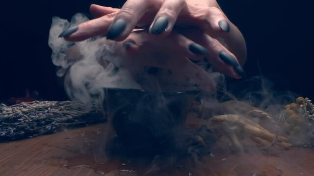 extreme close-up, detailed. hands of a witch with black nails above a bowl of thick white smoke.