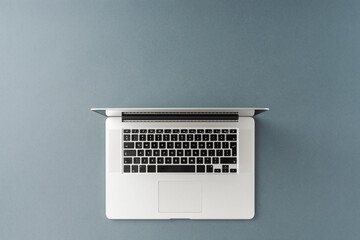 Overhead shot of laptop on gray background with copyspace. Office desktop. Flat lay