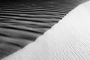 Black and White Sand beach macro photography. Texture of black and whote sand for background. Close-up macro view of volcanic sand surface black and white color. 