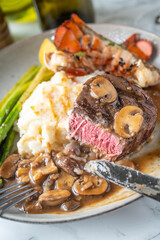 eating sruf and turf, tenderloin steak and lobster tail