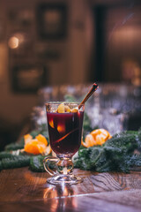 Red hot drink glintwein with spices, cinnamon, anise, fruits, brown sugar on an old wooden table. New Year and Christmas holidays concept. Mulled wine and glintwein.