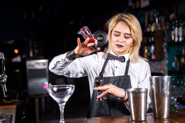 Girl bartender concocts a cocktail at the beerhouse
