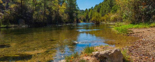 Cabriel River with crystal clear waters and surrounded by green vegetation in the mountains of...