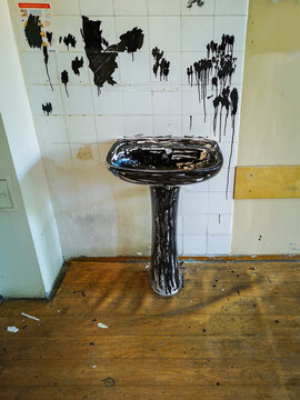 Old washbasin painted by marker in old abandoned hospital