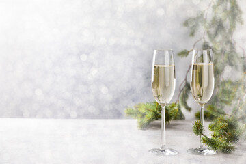 Christmas New Year Greeting Card .Glasses with champagne Christmas Tree.Copy space  Light Effect Bokeh.