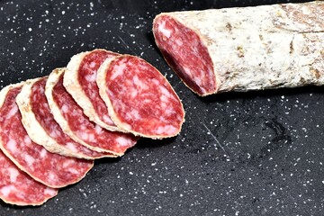 Slices of Italian artisanal Felino salami on a kitchen cutting board. Felino, Parma, Emilia Romagna / Italy