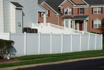 White vinyl fence in residential neighborhood nature