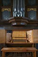Pipe organ console with two keyboards or manuals, stop knobs, pedal board, and case facade in the St. Mary's Church of Gudow, Germany