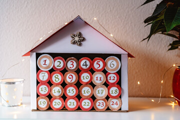 Handmade advent calendar house made from toilet paper rolls and carton. Sustainable Christmas,...