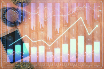 Multi exposure of financial chart hologram over desktop with phone. Top view. Mobile trade platform...