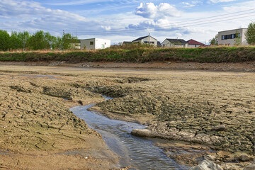 Empty and drained pond. Drought and no water in the landscape.