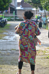 a grandmother was walking in the yard carrying her grandson