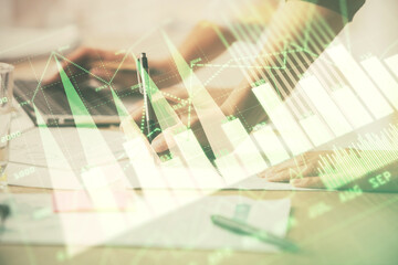 Multi exposure of woman hands typing on computer and financial chart hologram drawing. Stock market...