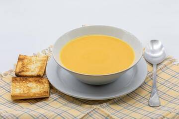 Traditional cream soup made of pumpkin and carrots in a ceramic bowl