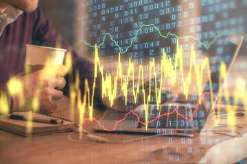 Double exposure of man's hands holding and using a phone and financial graph drawing. Analysis concept.