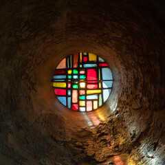 Colored stained glass window of an old chapel of Le Puy en Velay