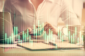 Double exposure of forex chart sketch hologram and woman holding and using a mobile device. Financial market concept.