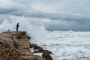 Pescatore e mareggiata a Sabaudia, Latina, Italia.