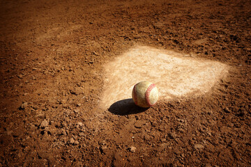 Baseball on home plate of dirt baseball field