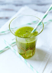 Green smoothie topped with chia seeds on bright wooden background. Close up.	
