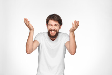 Fototapeta premium cheerful emotional bearded man gesturing with his hands close-up light background