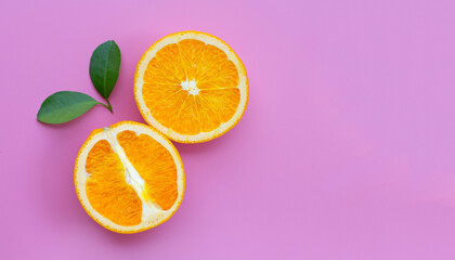 High vitamin C, Juicy and sweet. Fresh orange fruit with green leaves on pink background.