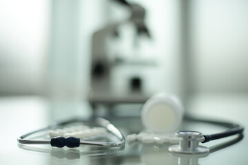 Pill stethoscope and microscope on glass table