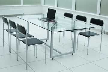 Black chairs glass table stethoscope laptop in office space