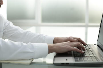 Office worker hands typing on laptop keyboard