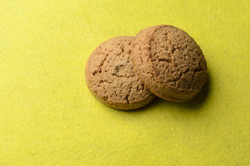 Oatmeal cookies on a blurry yellow background.