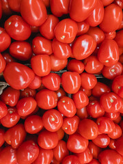 Red tomatoes in the supermarket. Red tomato background. A bunch of fresh tomatoes. Vertical image.