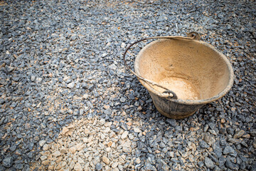 Plastic bucket concrete mixer for construction on rock surface.