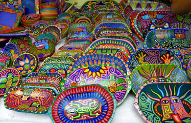 Andean Indigenous Culture of Tigua, Cotopaxi. Souvenirs plates made of wood, painted with striking colors acrylics. They portray animals, folklore characters