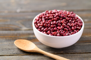 Azuki beans or red mung beans in a bowl and spoon on wooden table