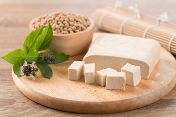 Fresh cube tofu and soybean seeds on wooden cutting board prepare for cooking, Asian vegan food