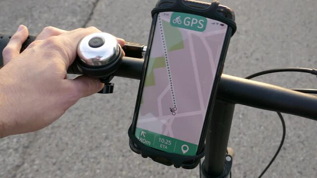Biking with a smartphone showing a GPS screen guiding the cyclist on the road.
