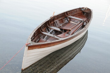 Row boat on very clear sea and its reflection